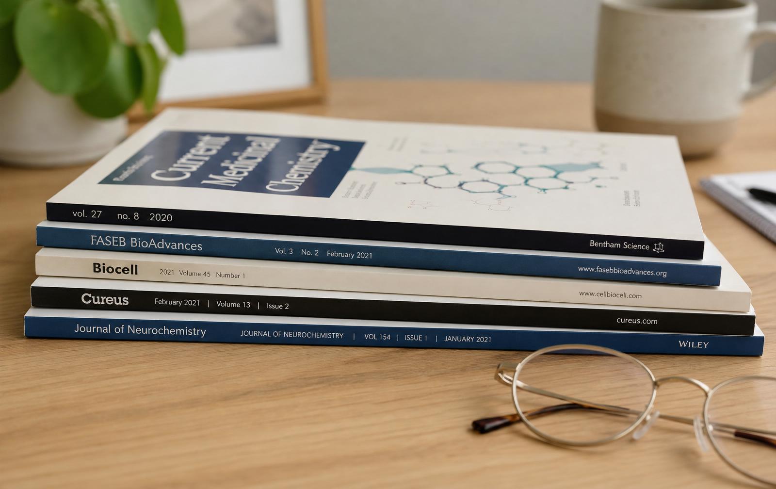 Stack of medical journals with reading glasses